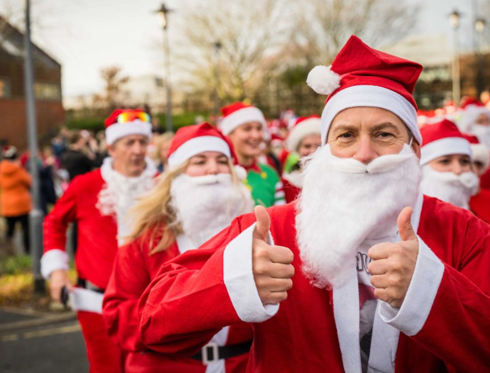 People dressed as Santas set off on the hospice's Santa Dash fun run. The person in the foreground is giving a thumbs up to the camera.